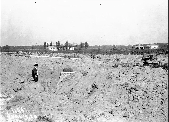 June 19, 1925. An engineer is inspecting a manhole structure and backfill along the Elmwood Park sewer along North Avenue. The backfill will be graded level and compacted below the top of the manhole to allow for street construction. With completion of the sewer, homes can be built in the underdeveloped area. (Metropolitan Water Reclamation District of Greater Chicago Archives)