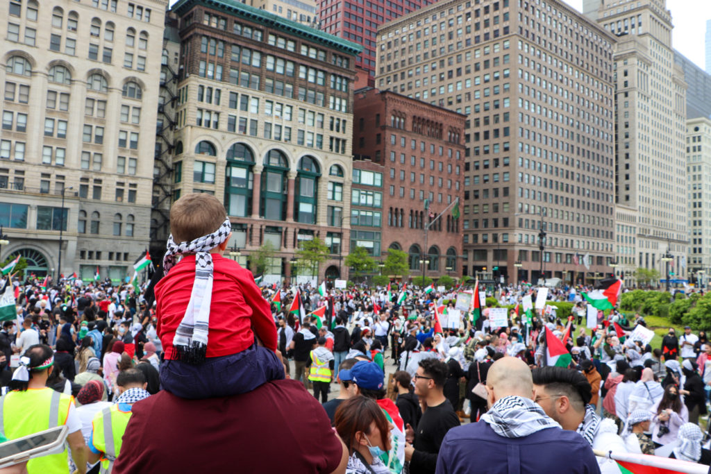 A demonstrator holds a small child on his shoulders to get a better look at the sprawling crowd, which included many families and children, gathered to support Palestine on May 16, 2021 in Chicago. (Madison Muller/South Side Weekly)