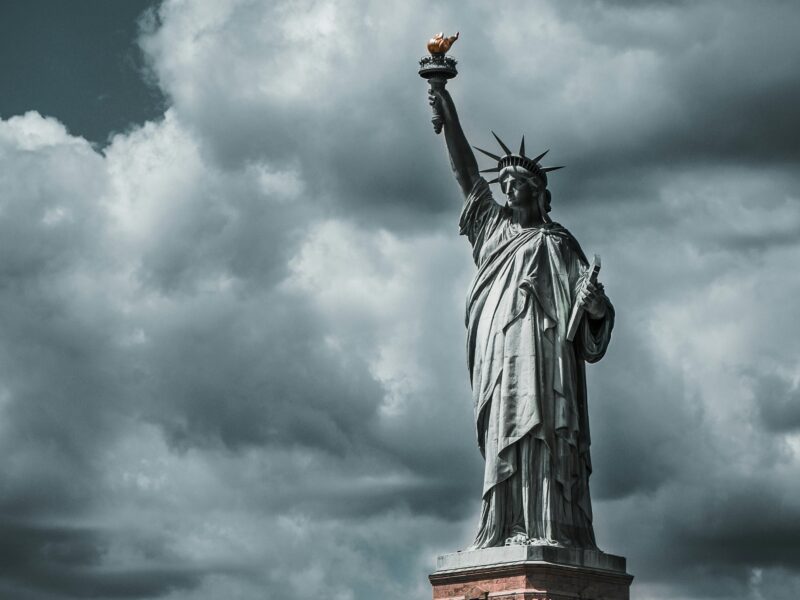 The Statue of Liberty is pictured under gathering gray storm clouds.